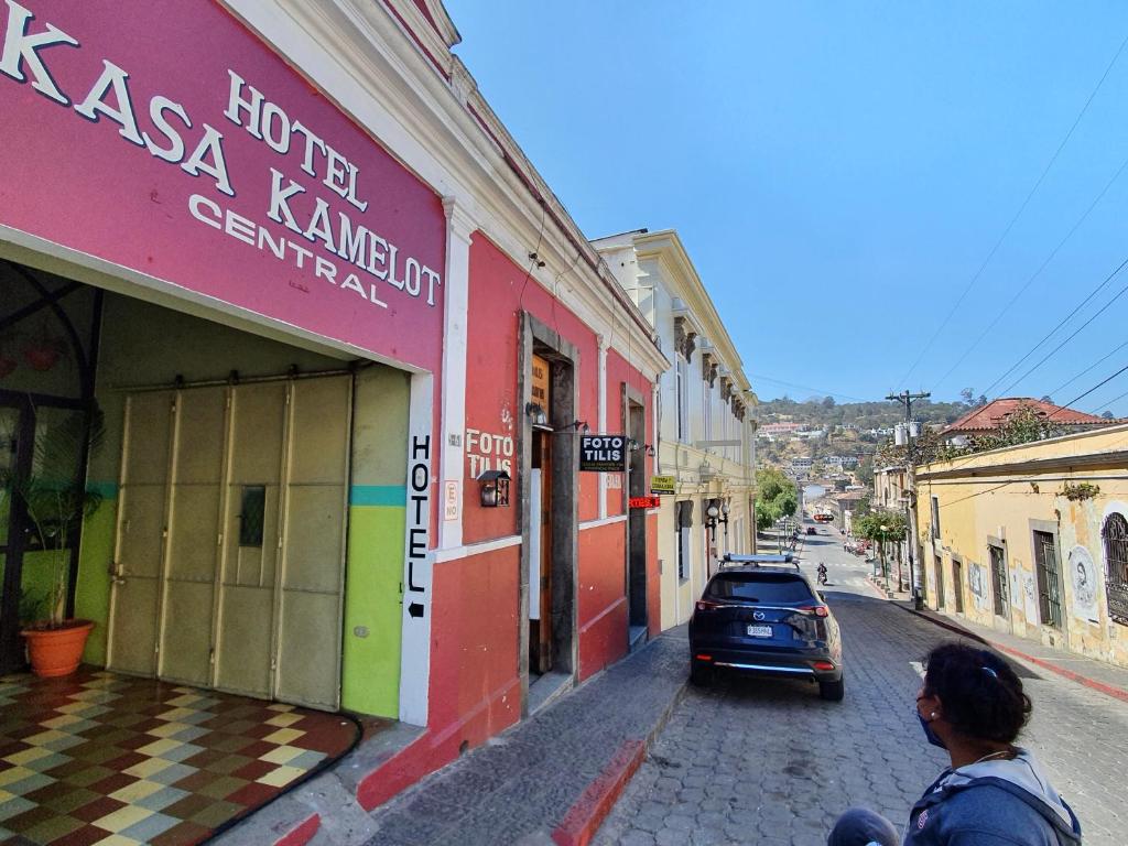 a woman walking down a street in a city at Hotel Kasa Kamelot Central in Quetzaltenango