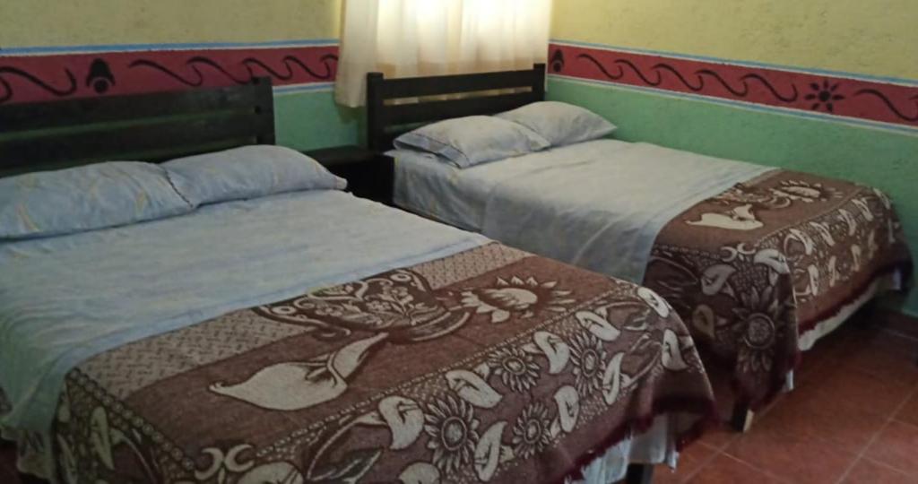 2 Betten nebeneinander in einem Zimmer in der Unterkunft El Portón de Cortés in Tepeaca