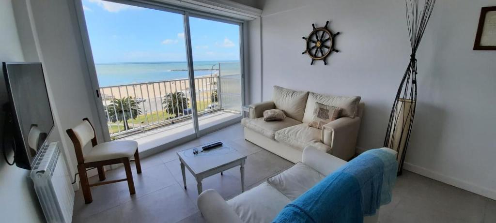 a living room with a couch and a view of the ocean at ALMAR III Sólo para familias in Mar del Plata
