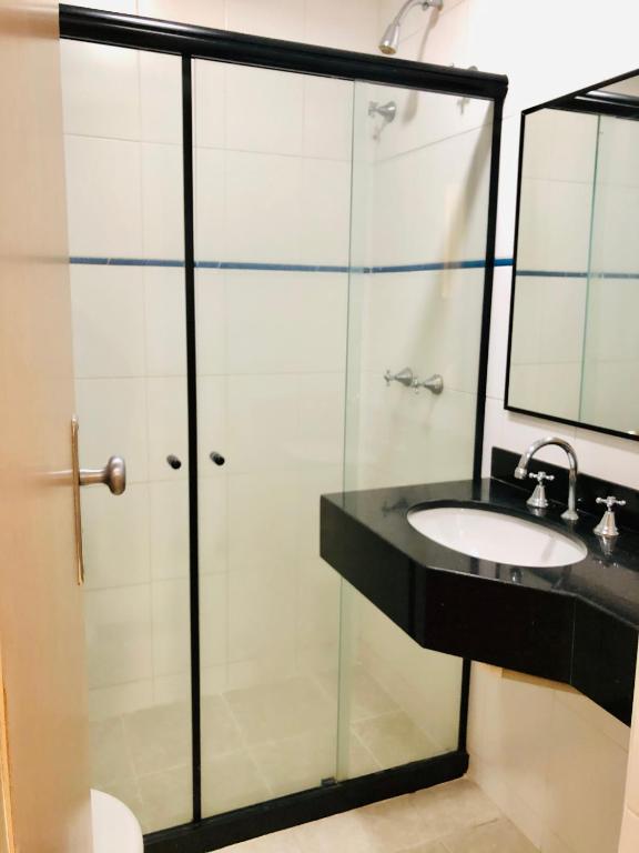 a bathroom with a glass shower and a sink at Hotel OK in Rio de Janeiro