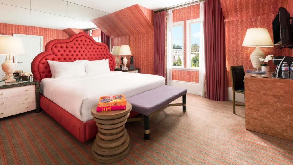 a hotel room with a large bed and a table at Maison 140 Beverly Hills in Los Angeles