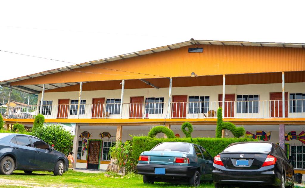 two cars parked in front of a building at Hotel Arbol de paz in San Ignacio