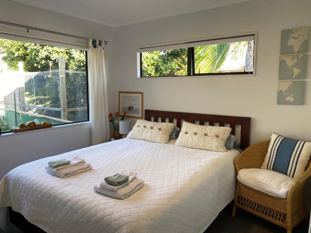 een slaapkamer met een bed met twee handdoeken erop bij Palm Garden Papamoa Beach Paradise in Papamoa