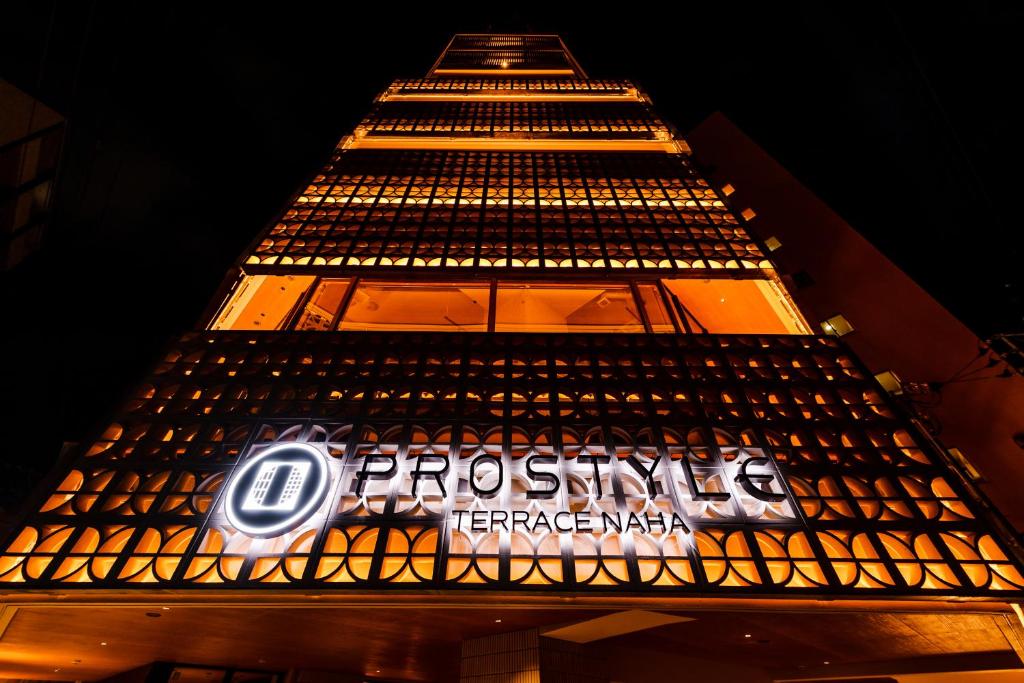 a tall building with a sign on it at night at PROSTYLE TERRACE NAHA in Naha