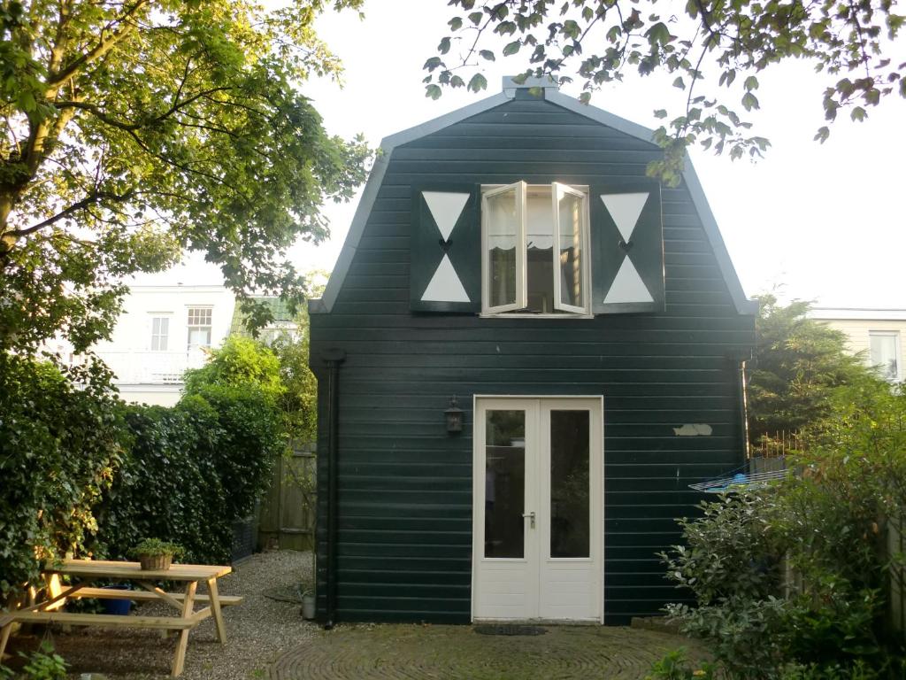 a black house with a white door and a table at Summerhouse Zandvoort in Zandvoort