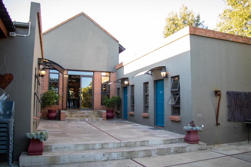 una casa con una puerta azul y unas escaleras en Bel Tramonto, en Bloemfontein