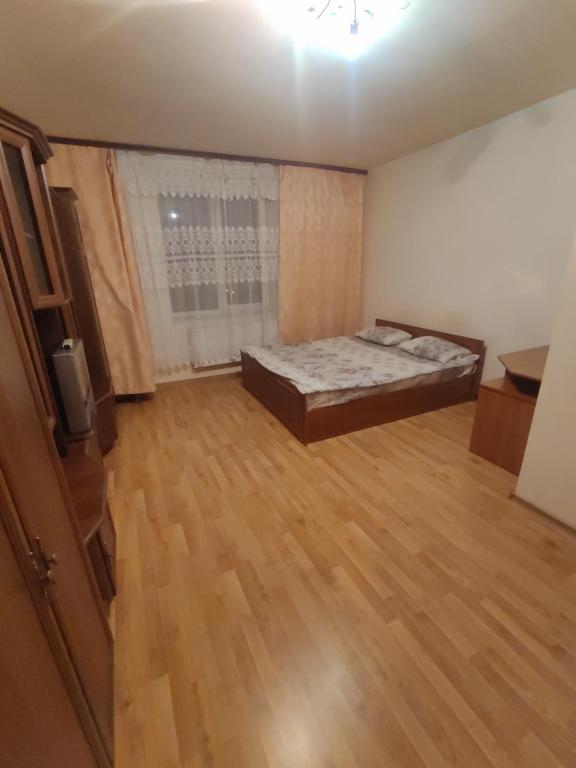 Un dormitorio con una cama y suelo de madera. en Daily rent Apartments 8, en Ivano-Frankivsk