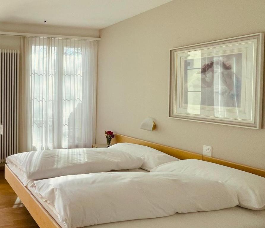 a bedroom with a large white bed in front of a window at Hotel Rössli in Basel
