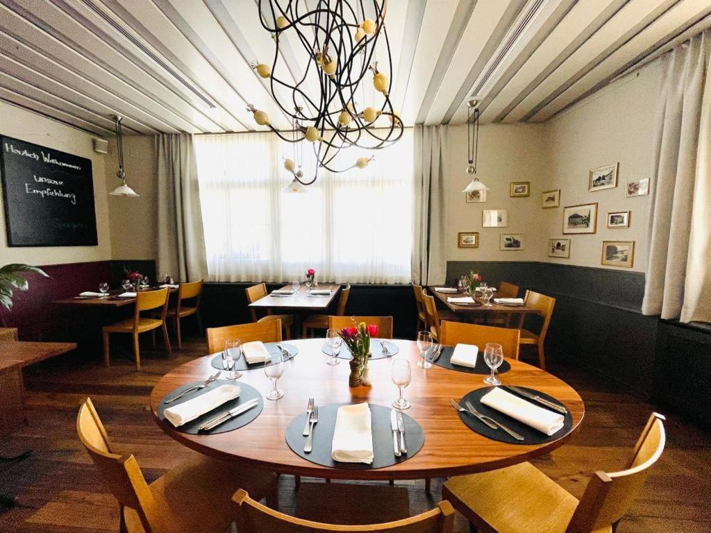 a dining room with a large wooden table and chairs at Hotel Rössli in Basel