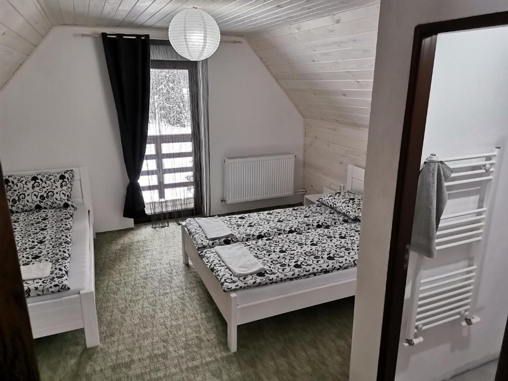 - une chambre avec 2 lits et une fenêtre dans l'établissement Izvorul Prigoanei, à Tău Bistra