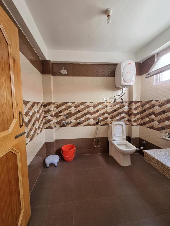 a bathroom with a toilet and a sink at Uncle Nomad in Manāli