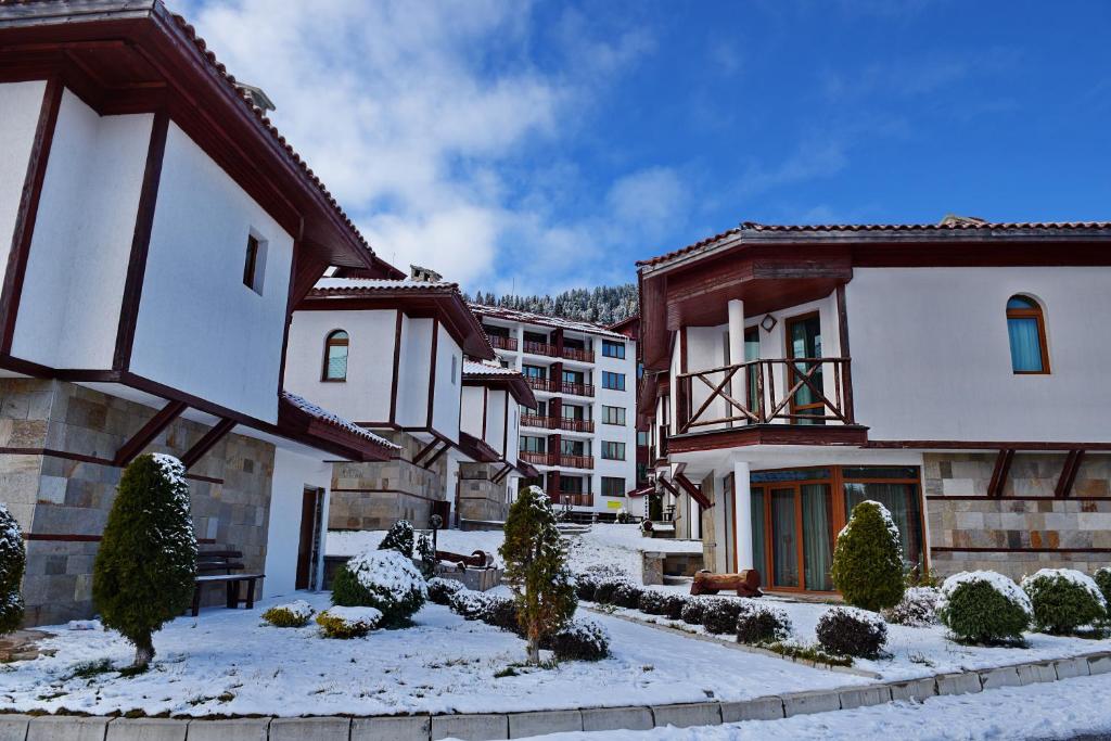 un grupo de edificios con nieve en el suelo en Forest Nook Villas, en Pamporovo