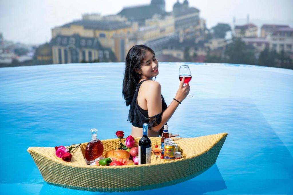 a girl in a boat with a glass of wine at Tubotel Sapa in Sa Pa