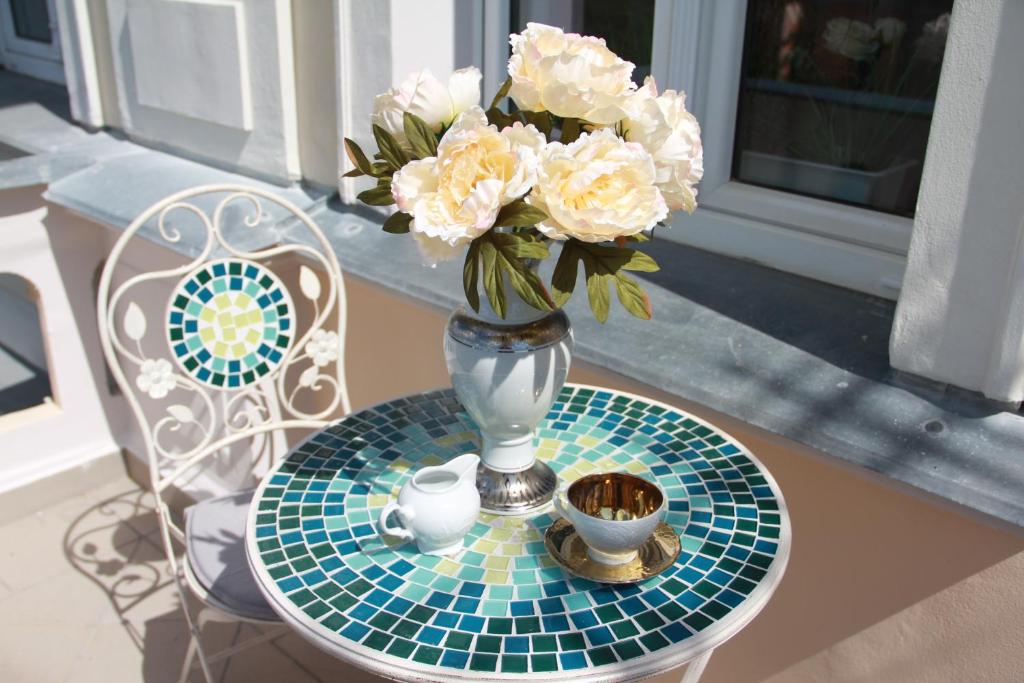 un vase avec des fleurs blanches assises sur une table dans l'établissement Jurincom apartments Kralovska Vyhlidka, à Karlovy Vary