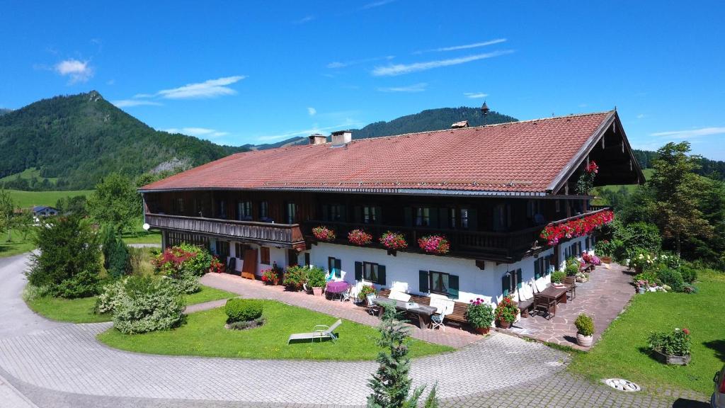 a large house with a red roof in a field at Stockinger Hof in Ruhpolding
