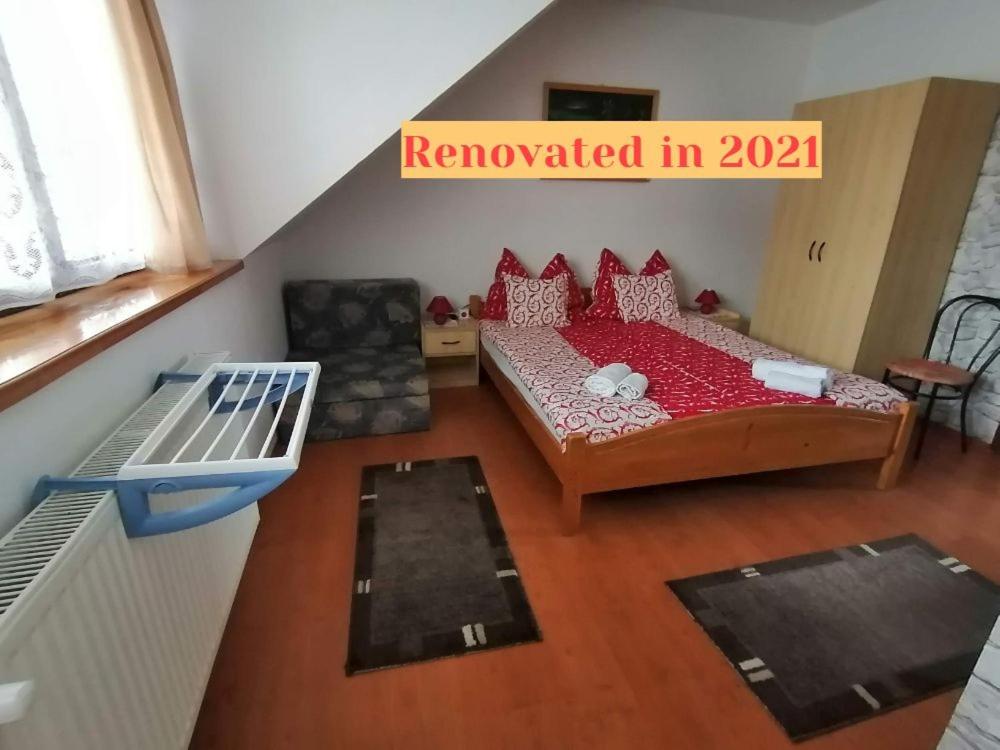 シャールヴァールにあるJoós Apartmanのベッド1台とソファが備わる小さな客室です。