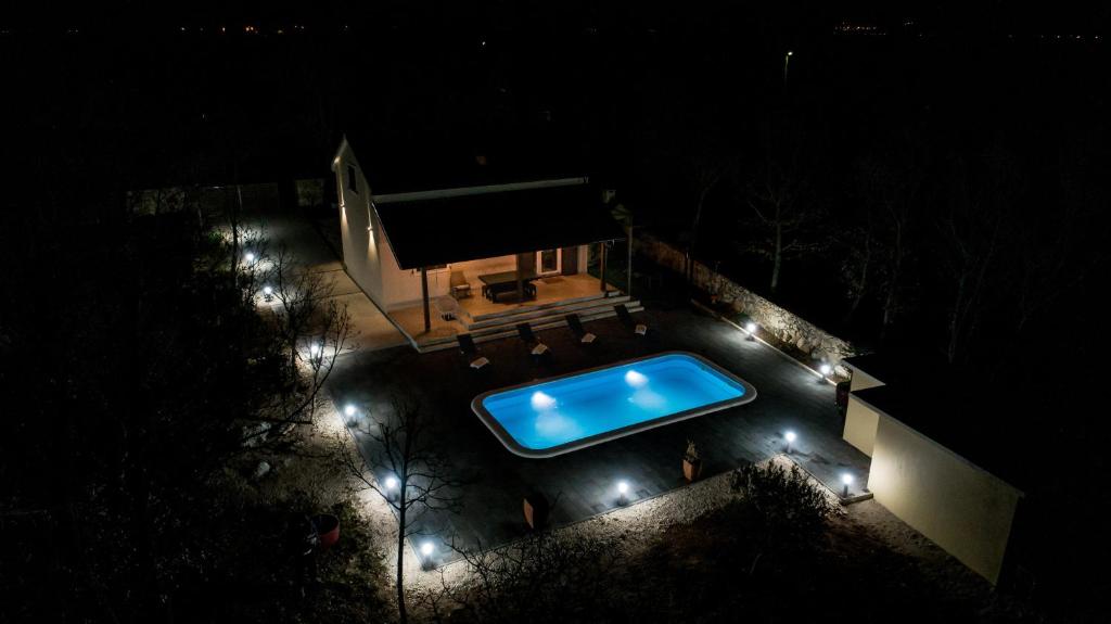 - une vue sur la piscine la nuit dans l'établissement Zen Promona, à Puljane