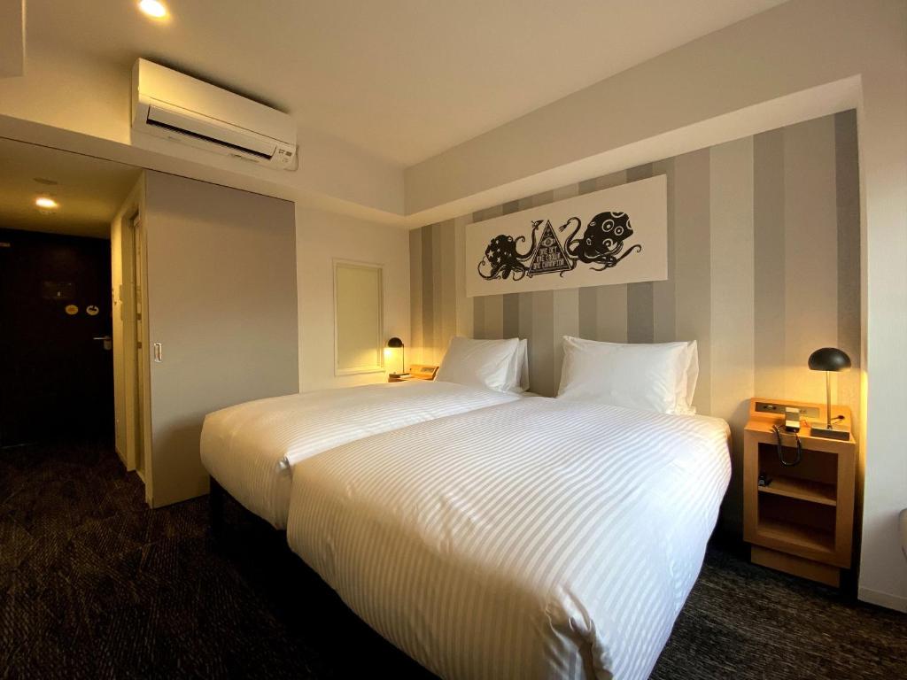 Postel nebo postele na pokoji v ubytování UMEDAHOLIC HOTEL