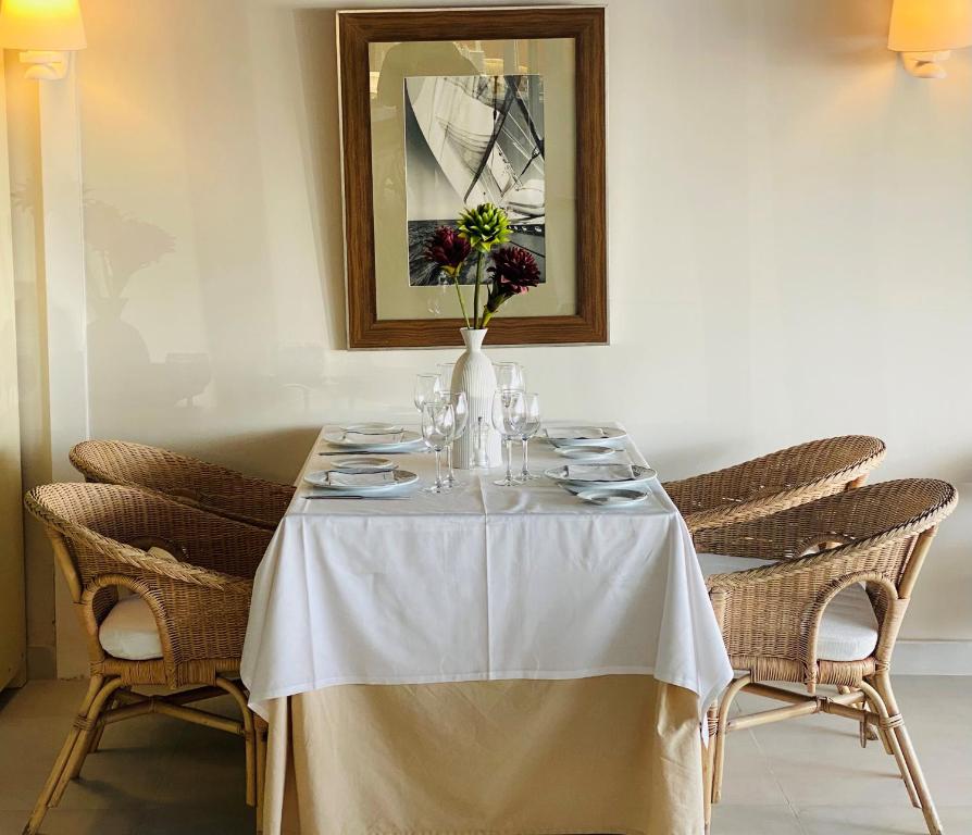 a table with a white table cloth and a vase with flowers at Hotel Playa Canet in Canet de Berenguer