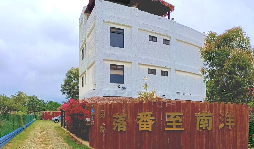 een wit gebouw met Aziatische letters op een rood hek bij Road Found in Jinning