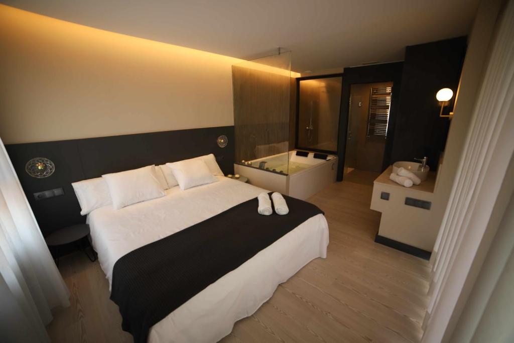 um quarto de hotel com uma cama grande e uma casa de banho em Masllosar Apartamento Rural Vilafranca em Villafranca del Cid