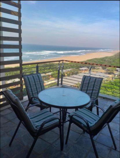 a table and chairs on a balcony with a view of the ocean at 53 Sancta Maria in Kingsburgh