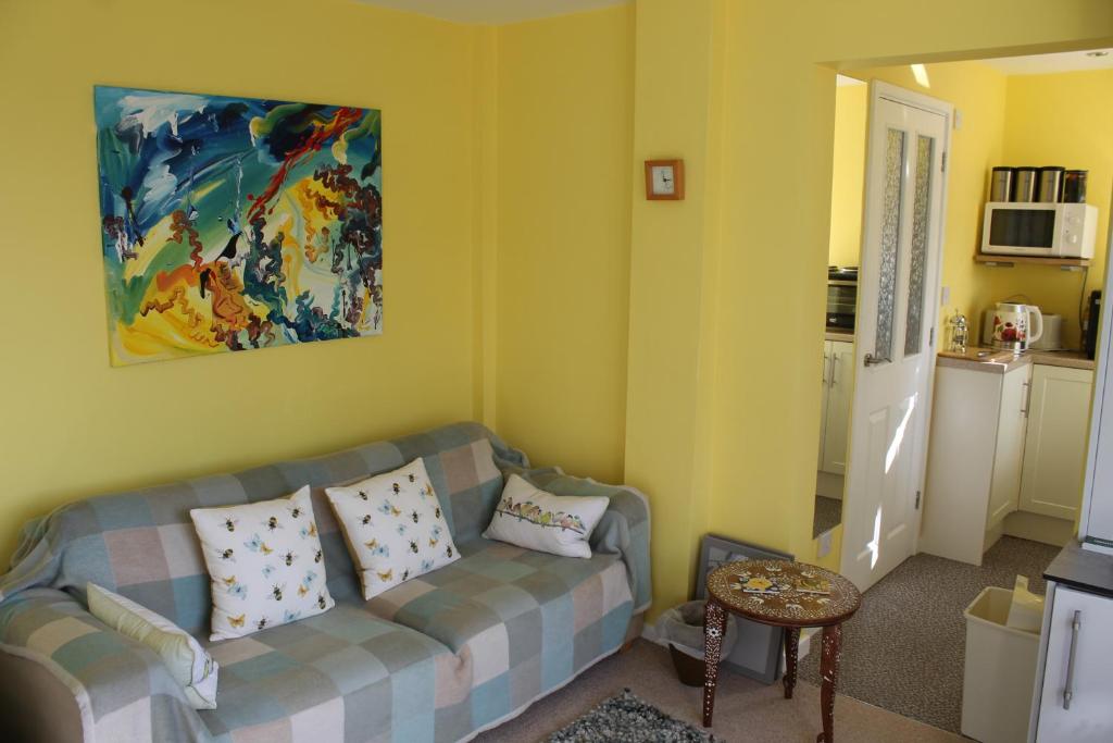 a living room with a couch and a painting on the wall at The Garden Room Westcott in Westcott