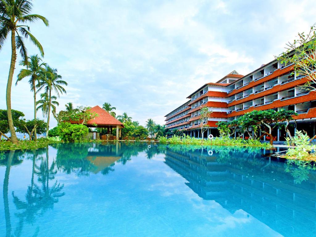 a swimming pool in front of a hotel at Hikka Tranz by Cinnamon in Hikkaduwa