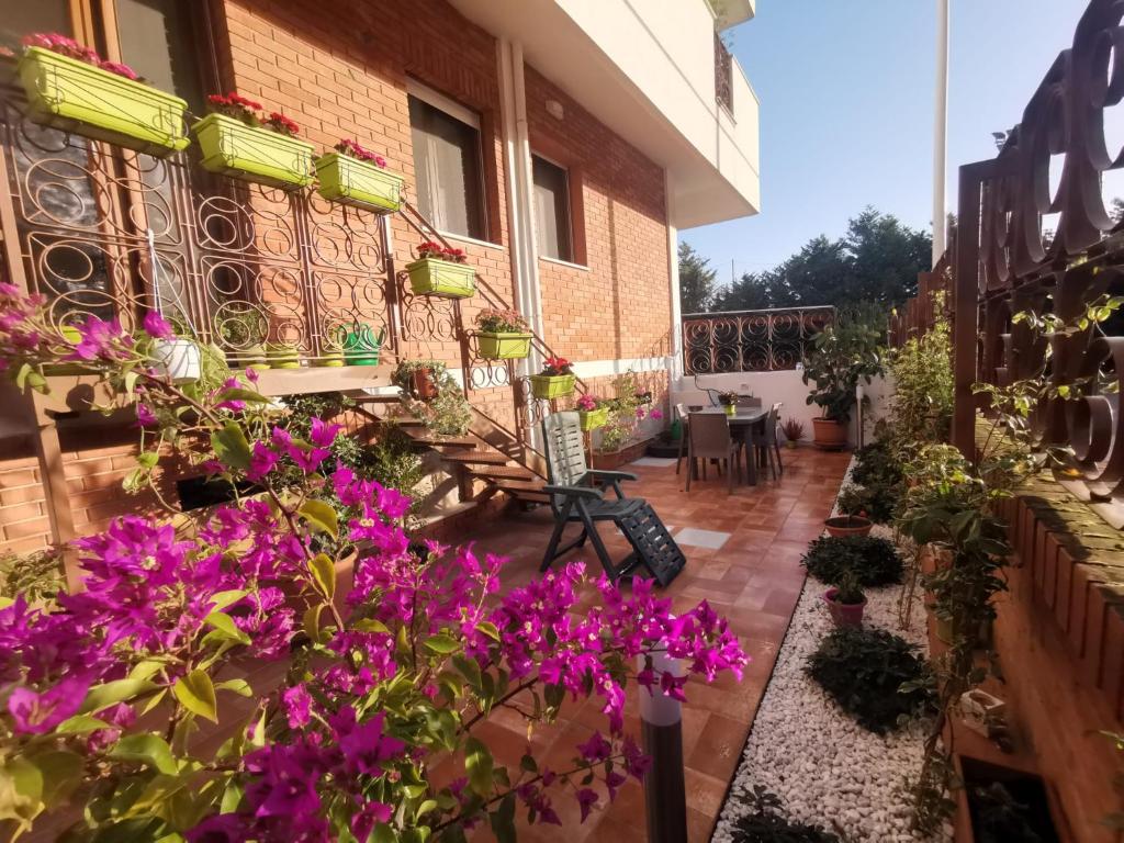 un patio con flores púrpuras en un edificio en Confortevole stanza privata in grazioso appartamento con giardino, en Cagliari