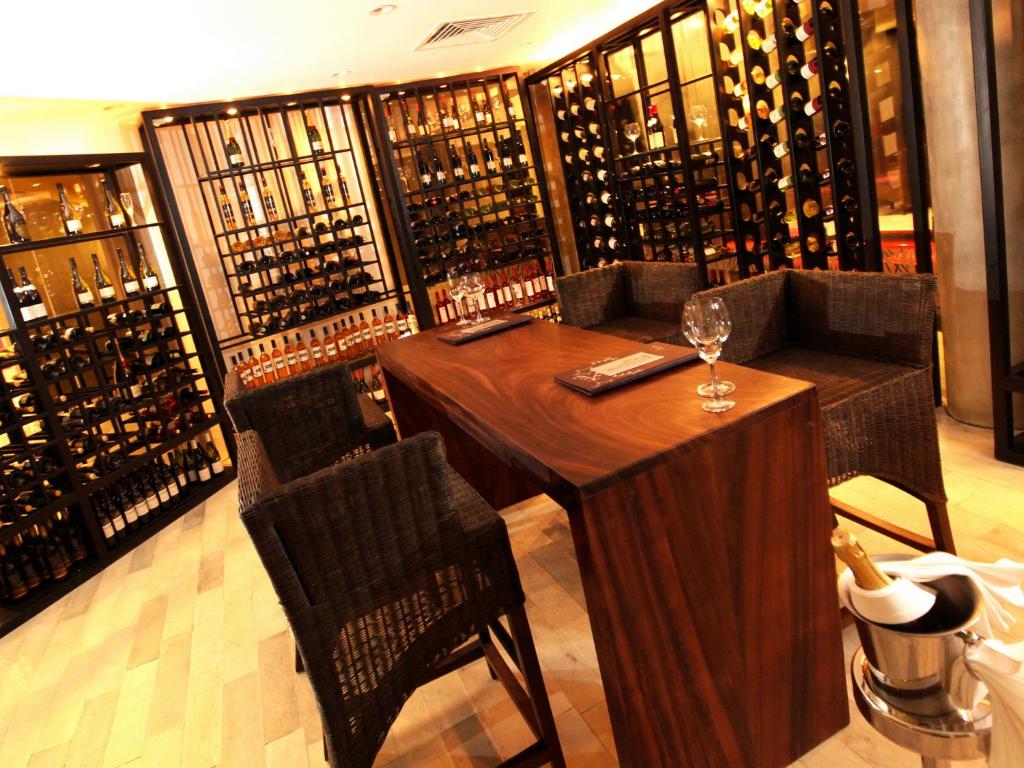 a wine cellar with a wooden table and chairs at Hikka Tranz by Cinnamon in Hikkaduwa