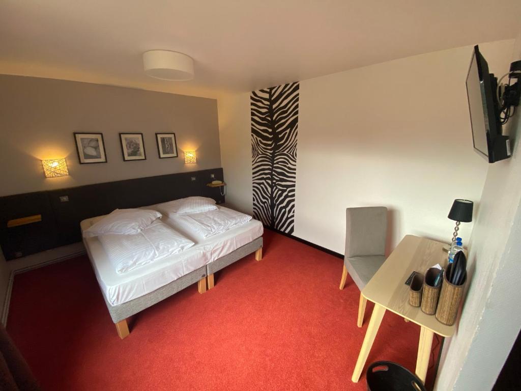 Postel nebo postele na pokoji v ubytování Hôtel Le Verger De Bischwiller