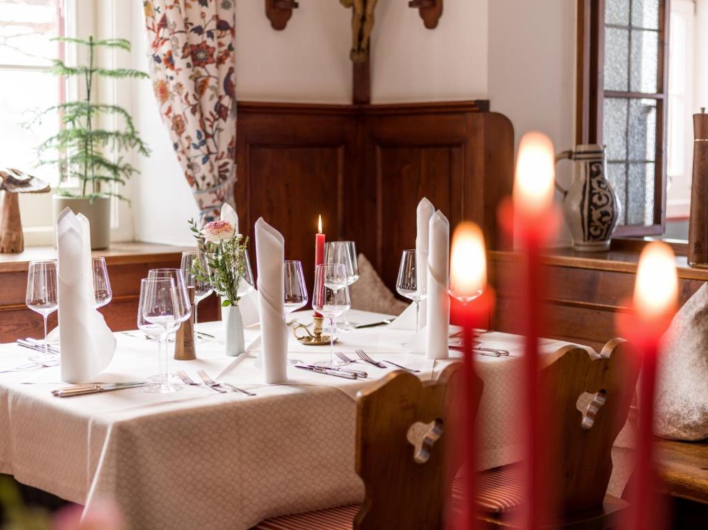 einen Tisch mit einem weißen Tischtuch und roten Kerzen in der Unterkunft Hotel Gasthof Blaue Quelle in 