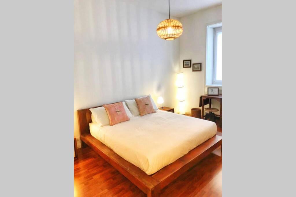 1 dormitorio con cama y lámpara de araña en “Dietro l’angolo” Charme & Relax nel centro città en Bérgamo