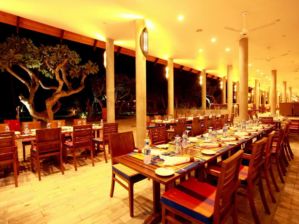 a large dining room with a long table and chairs at Hikka Tranz by Cinnamon in Hikkaduwa
