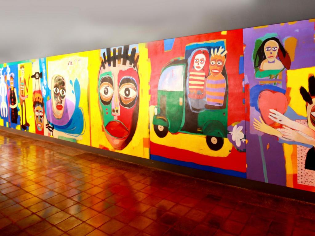 a wall with many different paintings on it at Hikka Tranz by Cinnamon in Hikkaduwa