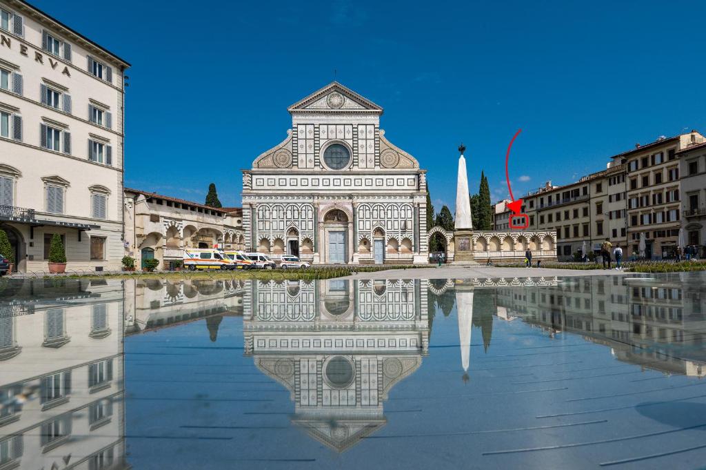 un edificio con il suo riflesso in una piscina d'acqua di Via Avelli, 4 - Florence Charming Apartments - Delightful and bright 3rd-floor apartment without elevator, overlooking one of Florence's most beautiful squares, Exceptionally located for exploring the city a Firenze