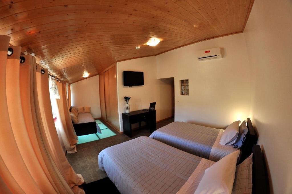 um quarto de hotel com duas camas e uma escrivaninha em Casa dos Hospitalrios em Alvaro