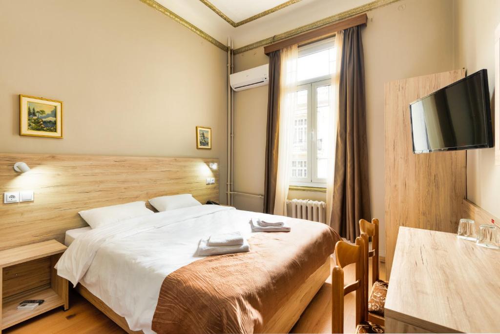 a bedroom with a large bed and a television at Nea Metropolis in Thessaloniki