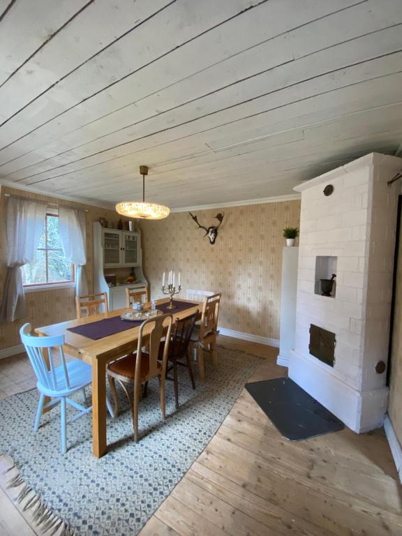 ein Esszimmer mit einem Tisch, Stühlen und einem Kamin in der Unterkunft Stora Mo in Tving