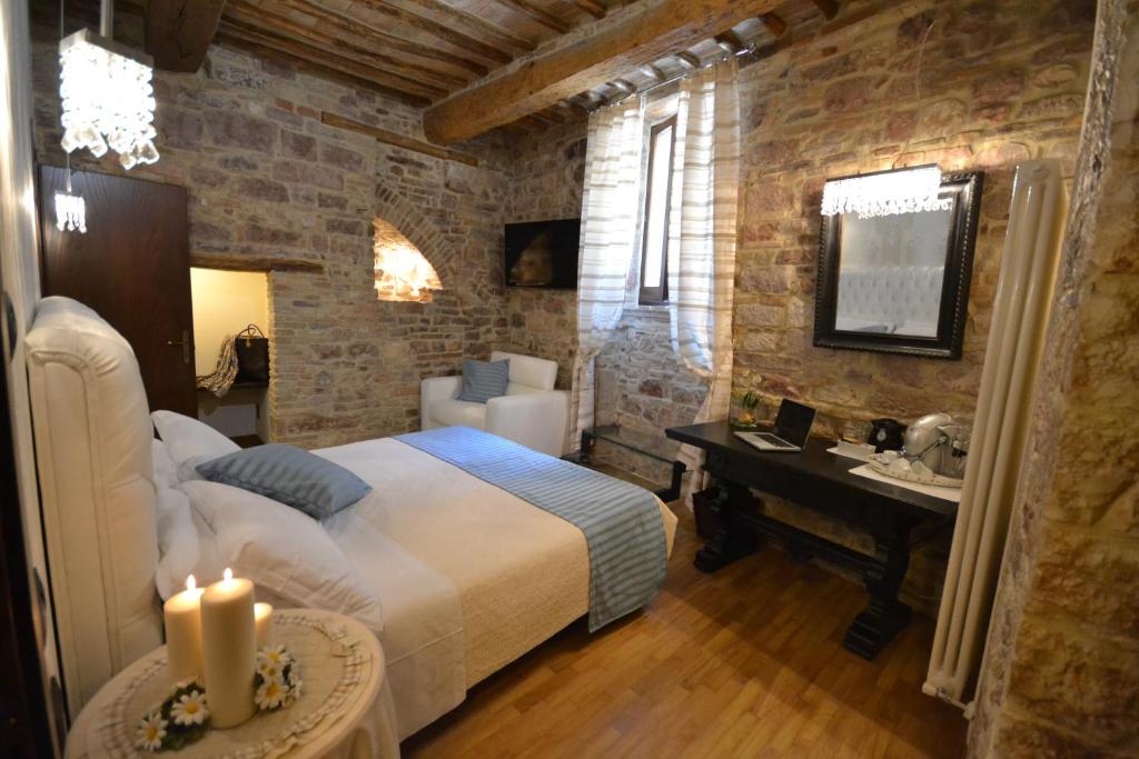 um quarto com uma cama, uma secretária e um lavatório. em Case Brizi Assisi em Assisi