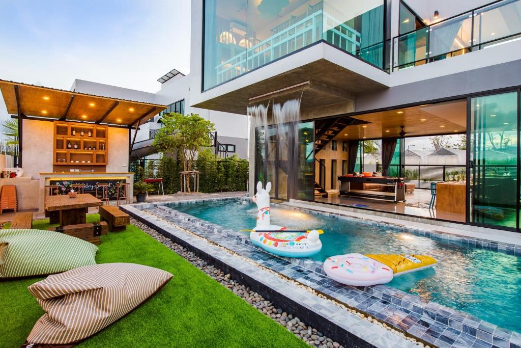 a house with a swimming pool with boats in it at Holiday Sunset Private Pool Villa in Hua Hin