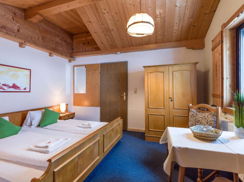 a room with two beds and a table and chairs at Pension Konrad in Söll