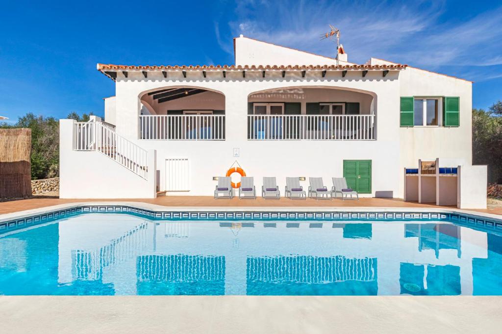 uma villa com piscina em frente a uma casa em Villa Jasmin em Sant Lluis