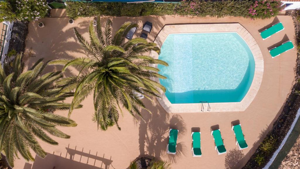 una vista aérea de una piscina y palmeras en Villa NARE - Casa típica majorera, en Villaverde