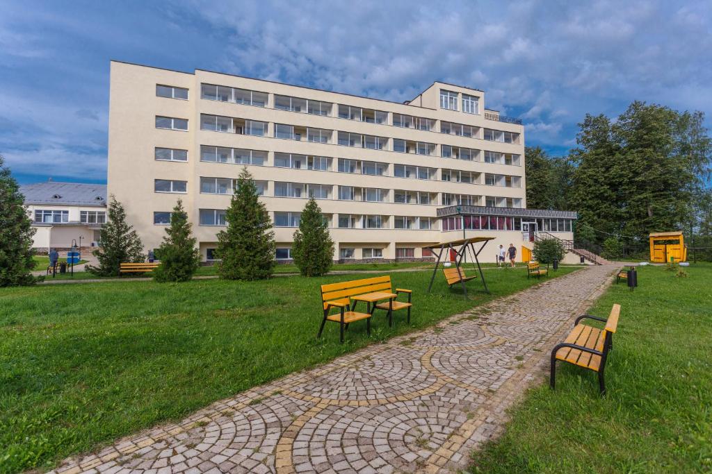 un edificio con un parque con bancos y un parque infantil en AMAKS Valdaiskie Zori, en Valday