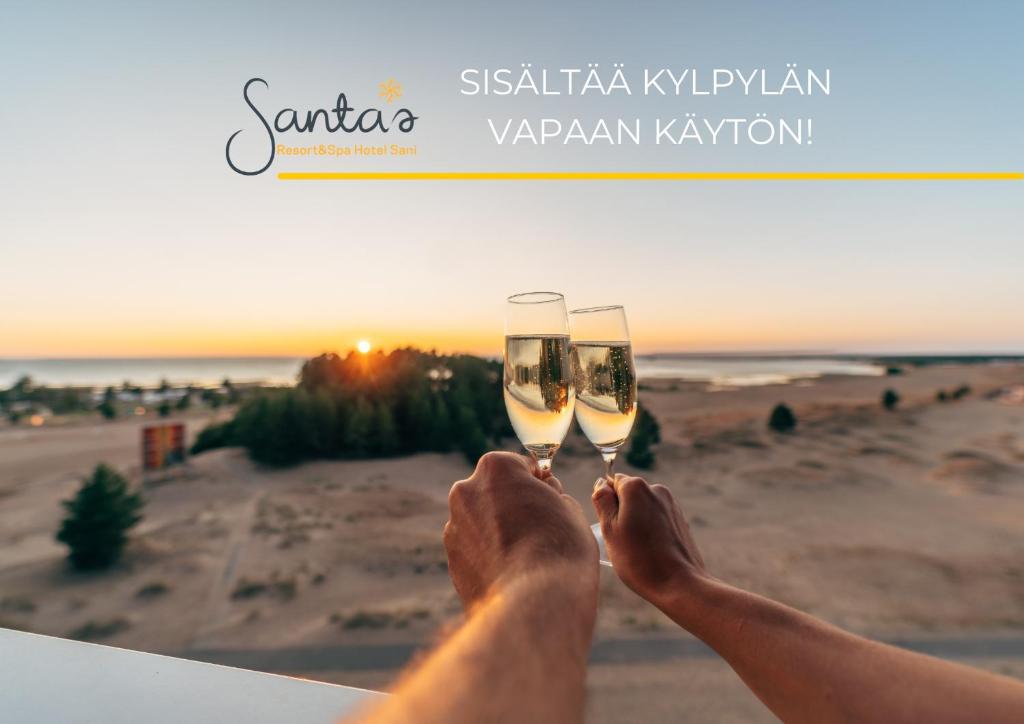 Een man met twee glazen champagne op het strand. bij Santa's Resort & Spa Hotel Sani in Kalajoki