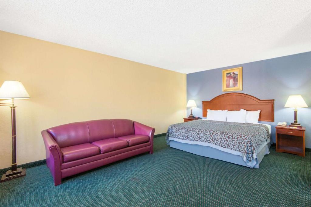 a hotel room with a bed and a couch at Blue Way Inn & Suites Wichita East in Wichita