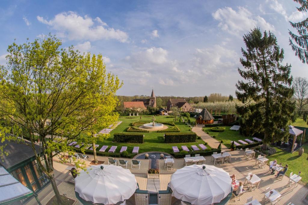 een luchtzicht op een tuin met tafels en parasols bij Hotel Gowell Kuur- en Wellness Yolande Buekers in Wellen