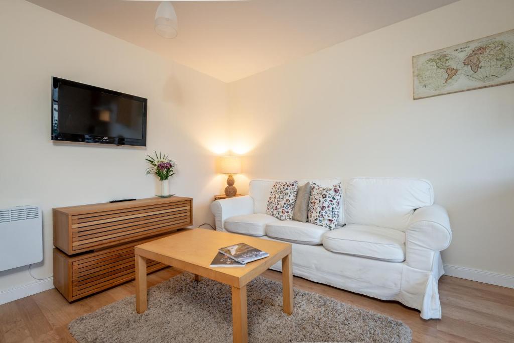 ein Wohnzimmer mit einem weißen Sofa und einem Couchtisch in der Unterkunft 2 Bedroom Apartment in a Quiet Neighbourhood in St Andrews