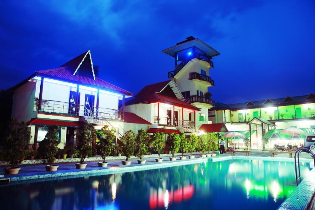 un resort con piscina e faro di notte di Maa Greenary View - A Holiday Resort a Alīpur Duār
